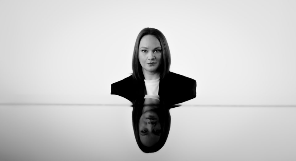 Zwart-witportret van pianiste Maria Nemtsova, weerspiegeld in een glanzend oppervlak