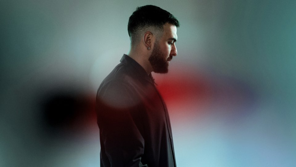 Transparent Man in profile against a soft blurred background of teal and red light