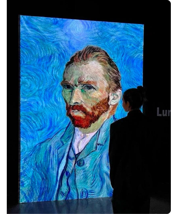Visitor in front of the Van Gogh self-portrait at Vincent Hall Amsterdam